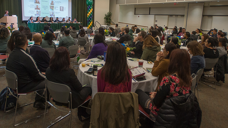 A group of advisors listen to a speaker during a conference.