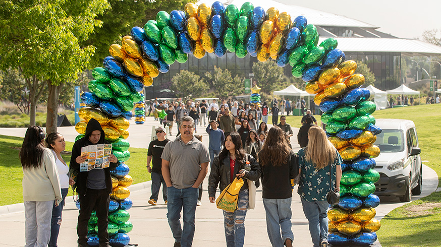 A family walks through balloon arch during Open House 2023